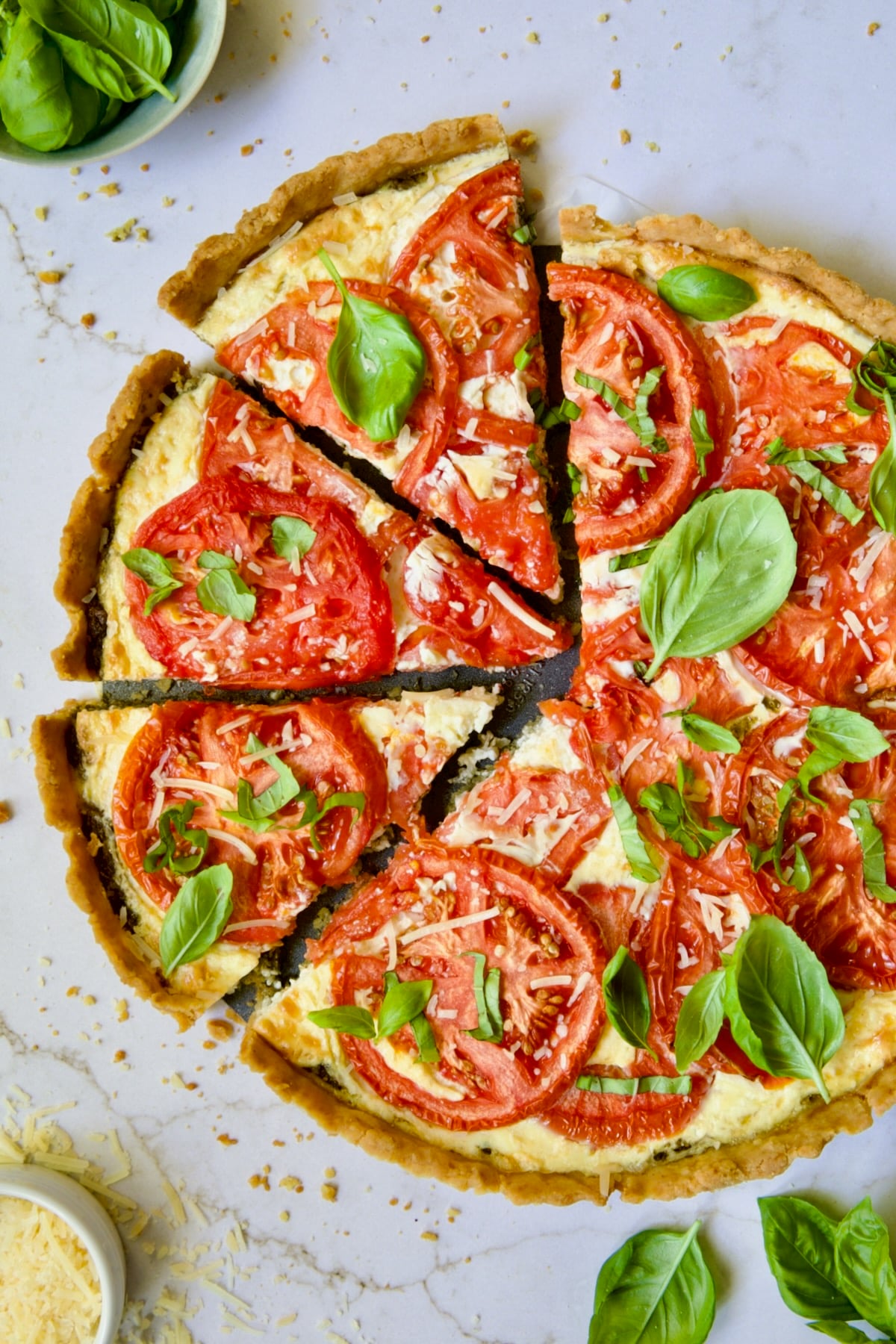 Tomato Tart with Ricotta and Cheese sliced into wedges and garnished with fresh basil leaves.