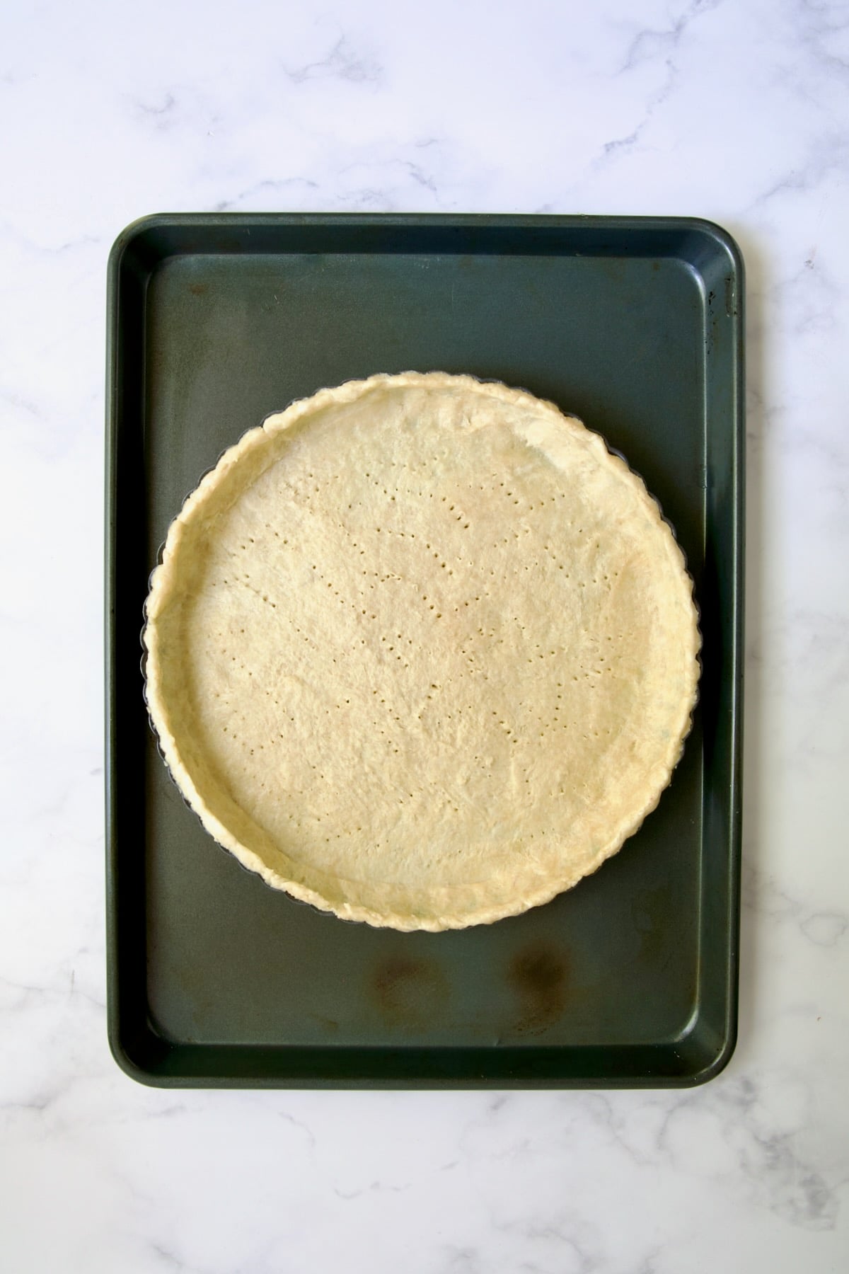 Tart crust on rimmed sheet pan before being blind baked.