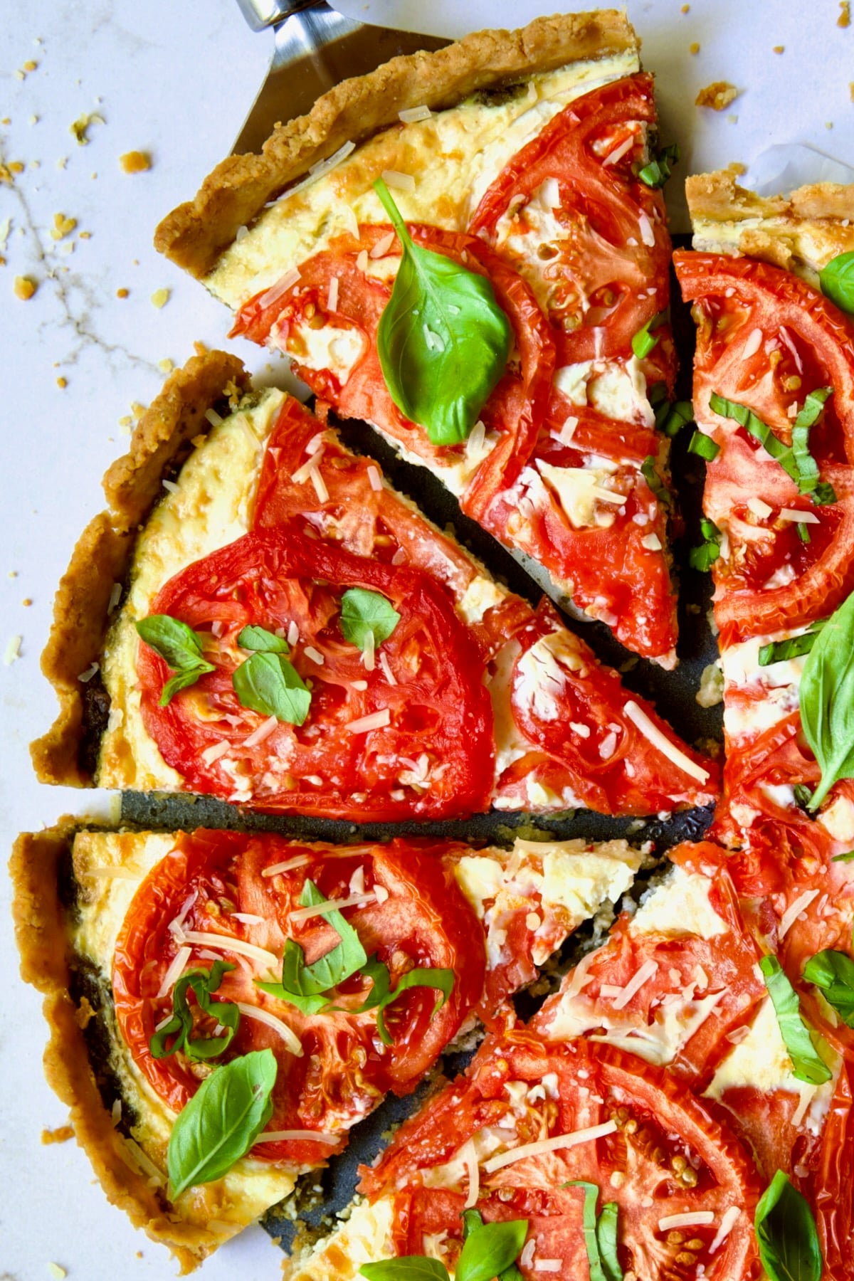 Tomato Tart with Ricotta and Cheese sliced into wedges and garnished with fresh basil leaves.