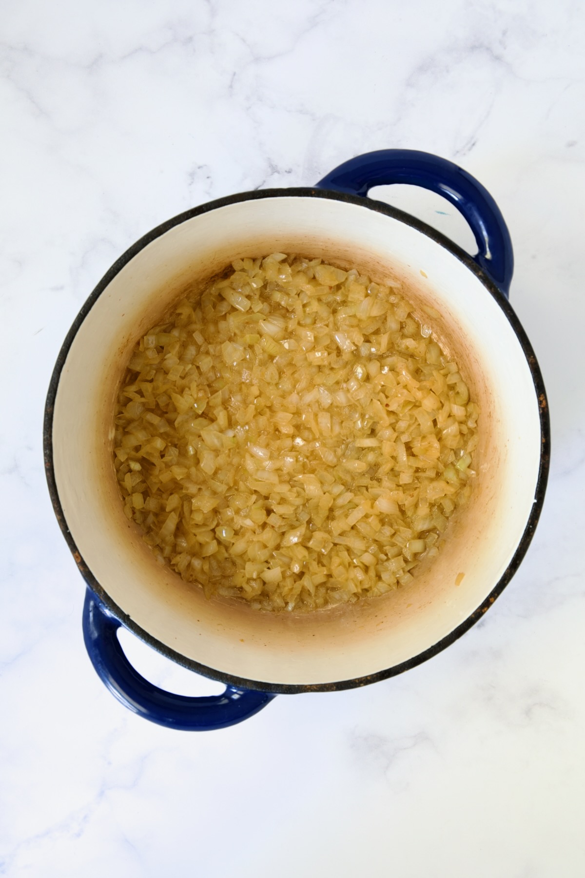 Cooked onions in blue Dutch oven.