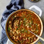 Hamburger Vegetable Soup in white Dutch oven with soup ladle.