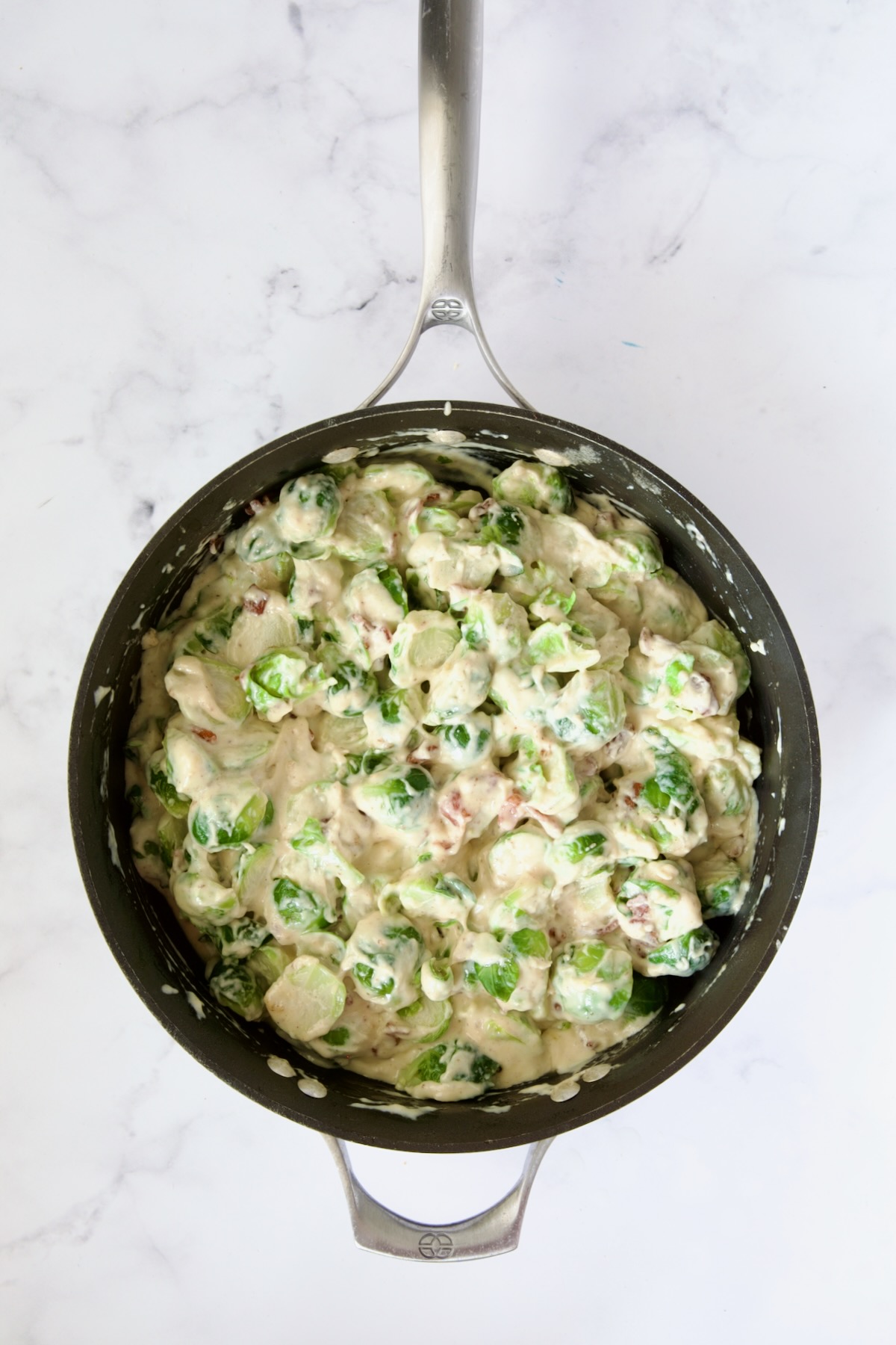 Blanched Brussels sprouts and bacon combined with the cheese sauce in nonstick skillet.