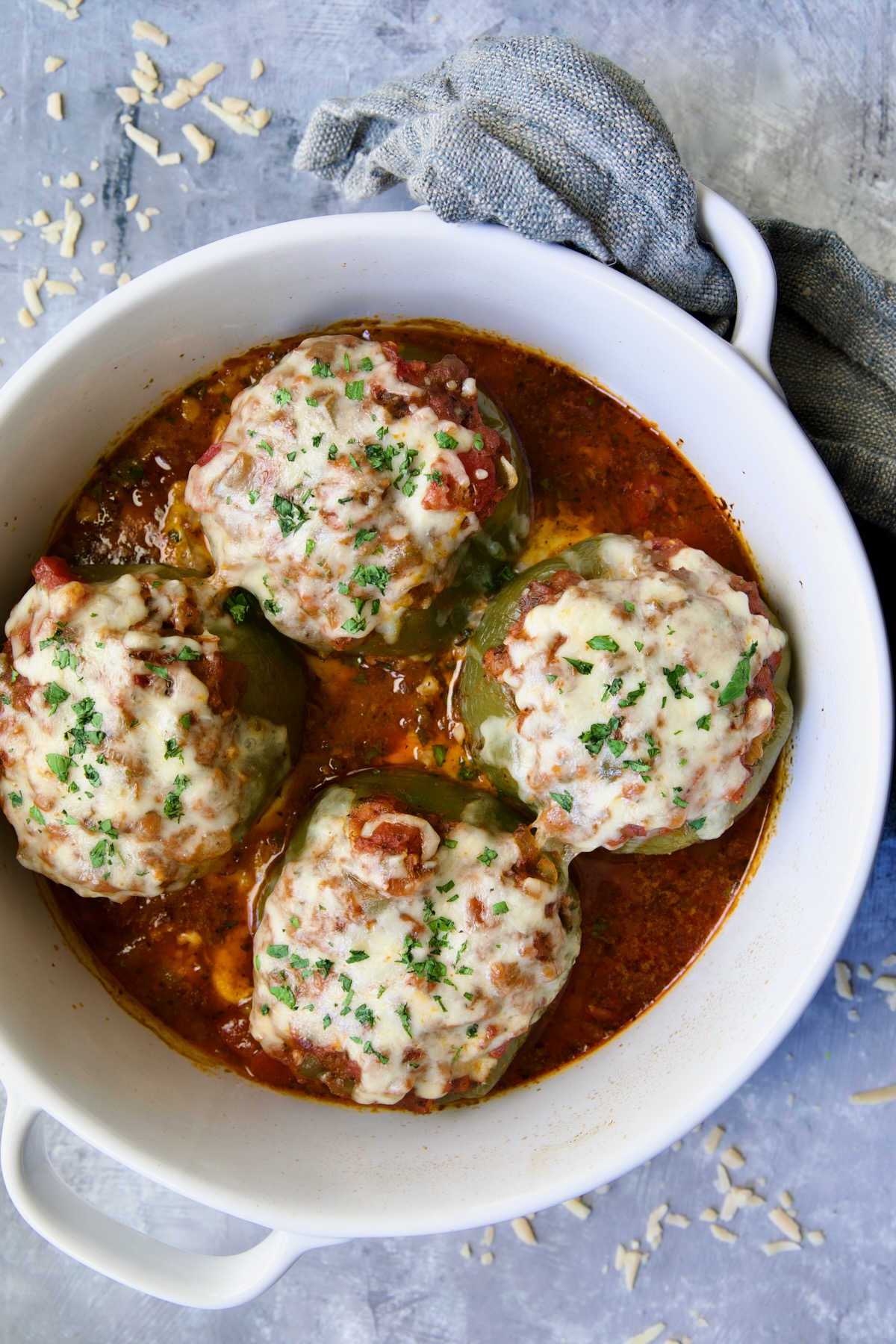 Four Italian Stuffed Peppers in deep white round baking dish.