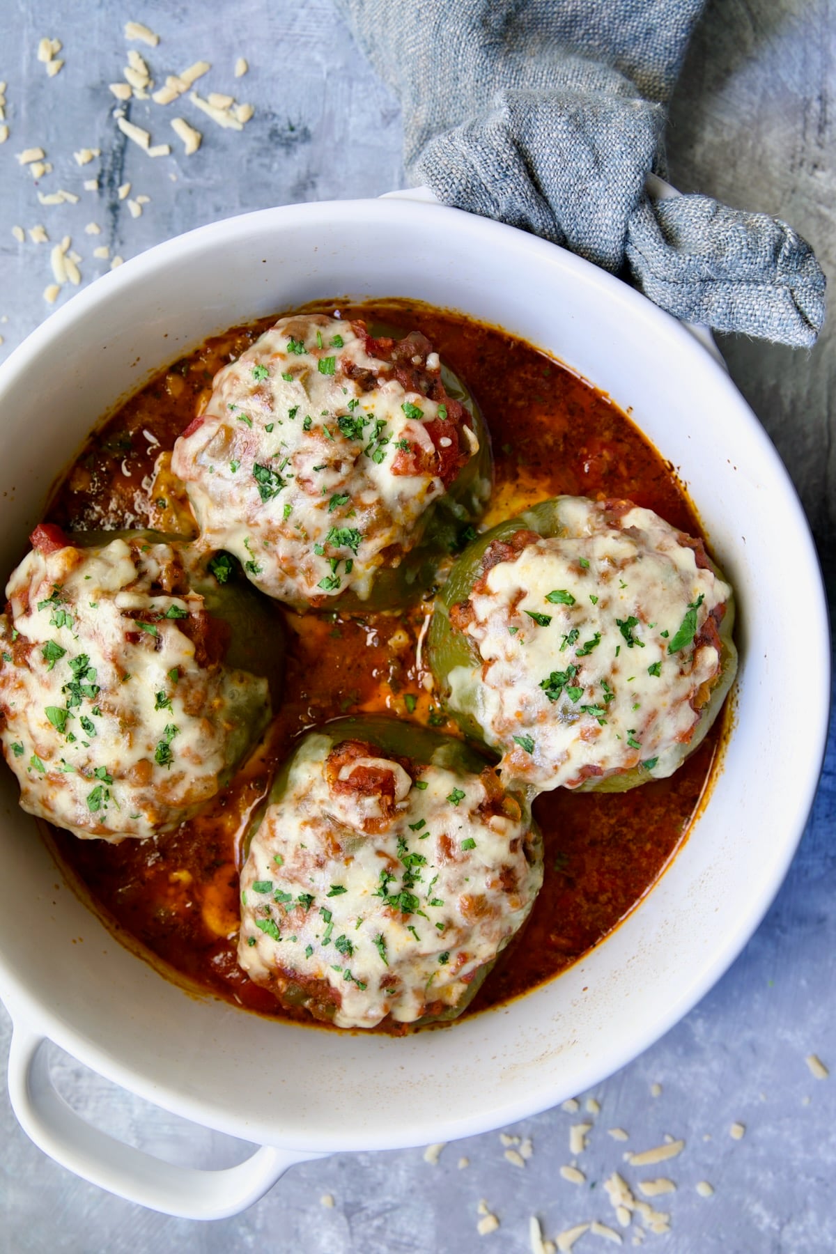 Four Italian Stuffed Peppers in deep white round baking dish.