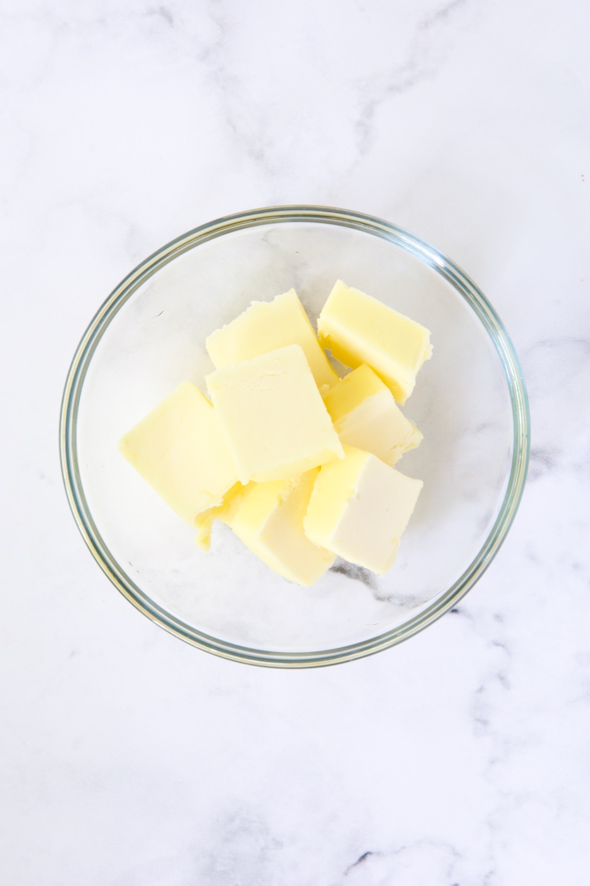 Slices of butter in glass bowl before being melted.