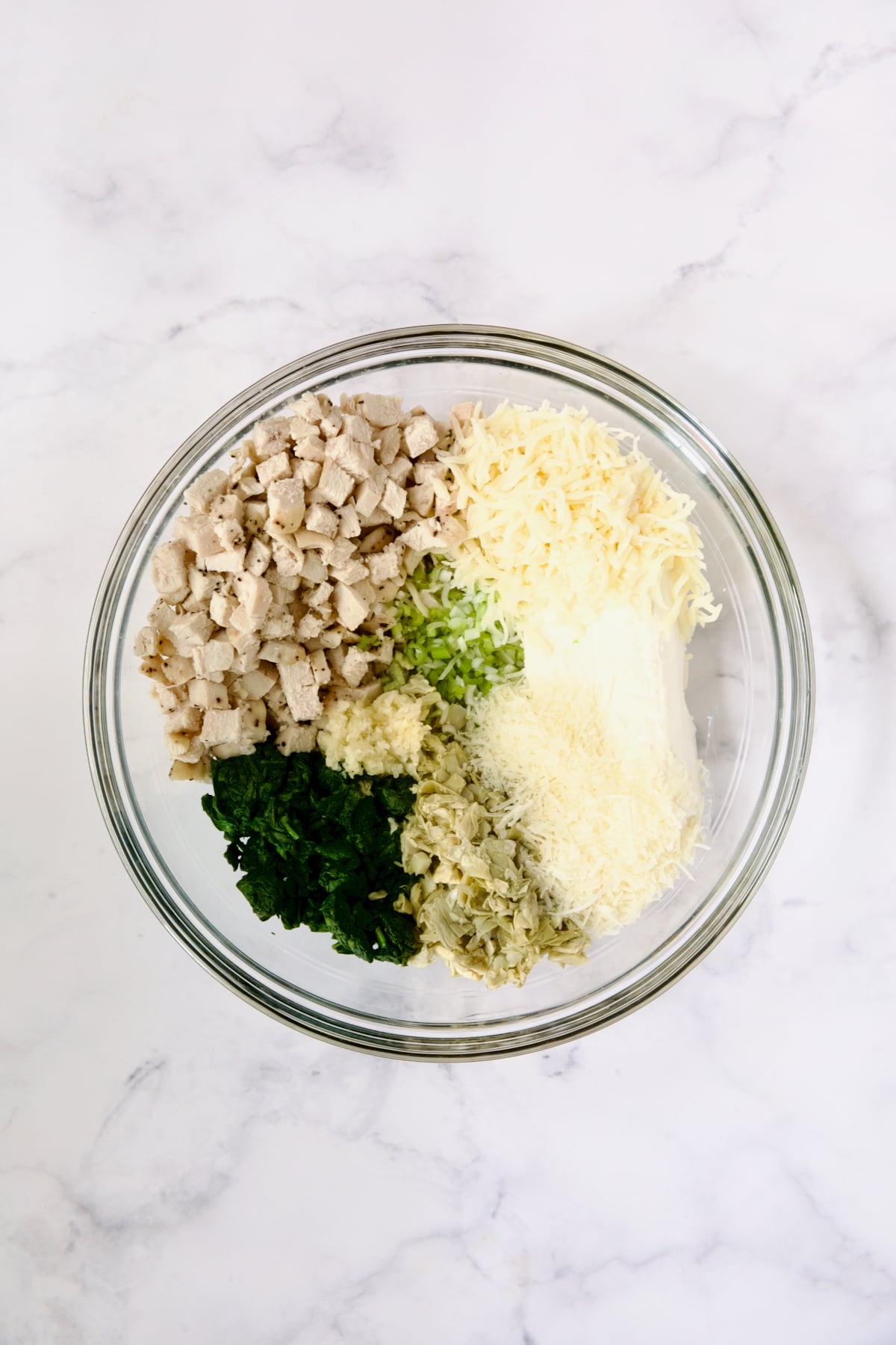 Filling ingredients for cannelloni in glass bowl before being combined.