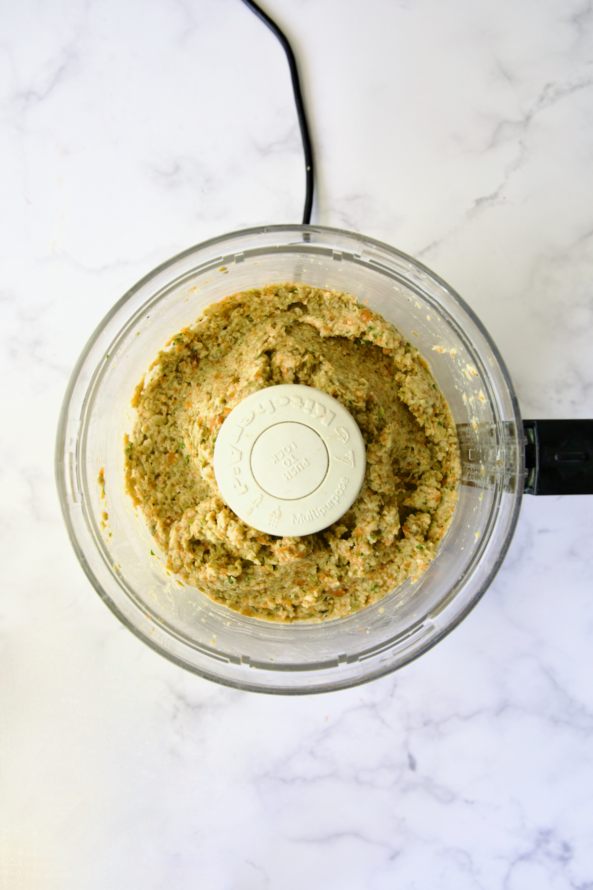 Tapenade in bowl of food processor after being pureed.