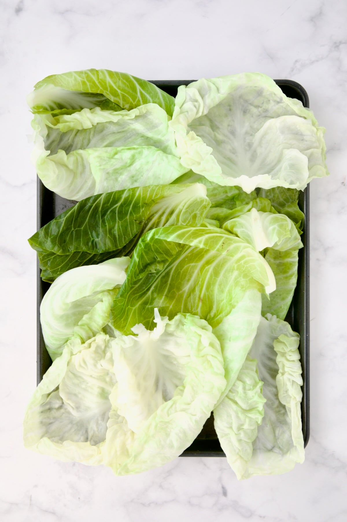 12 lettuce leaves on rimmed baking sheet.