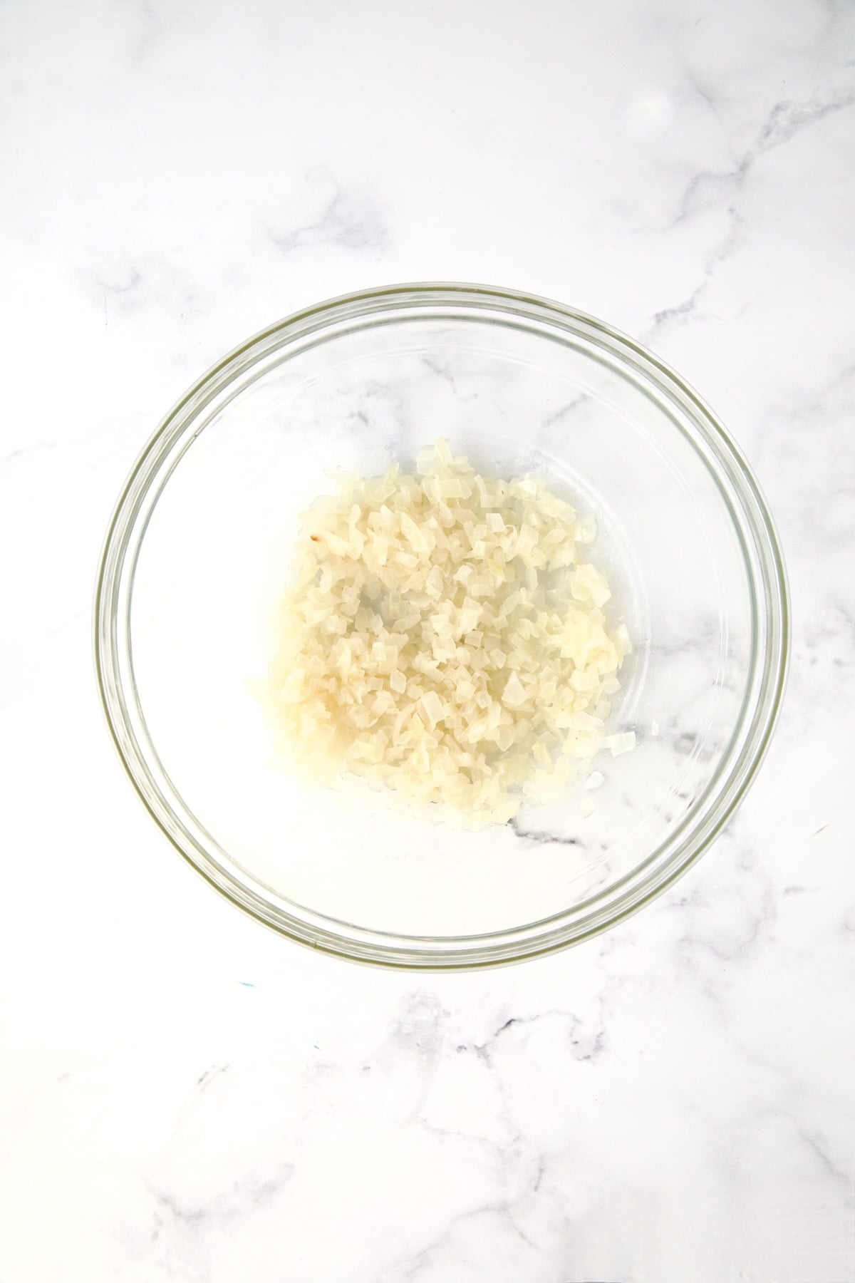 Half of the cooked onions in glass bowl.