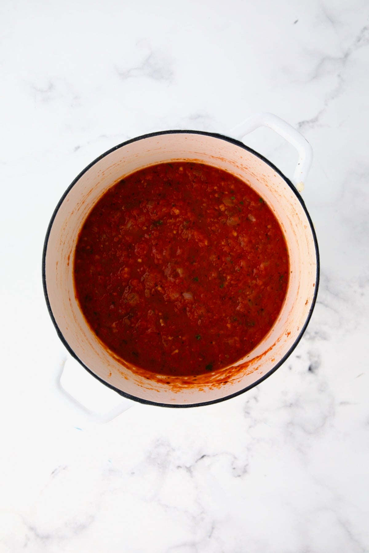 Tomato sauce in white Dutch oven.
