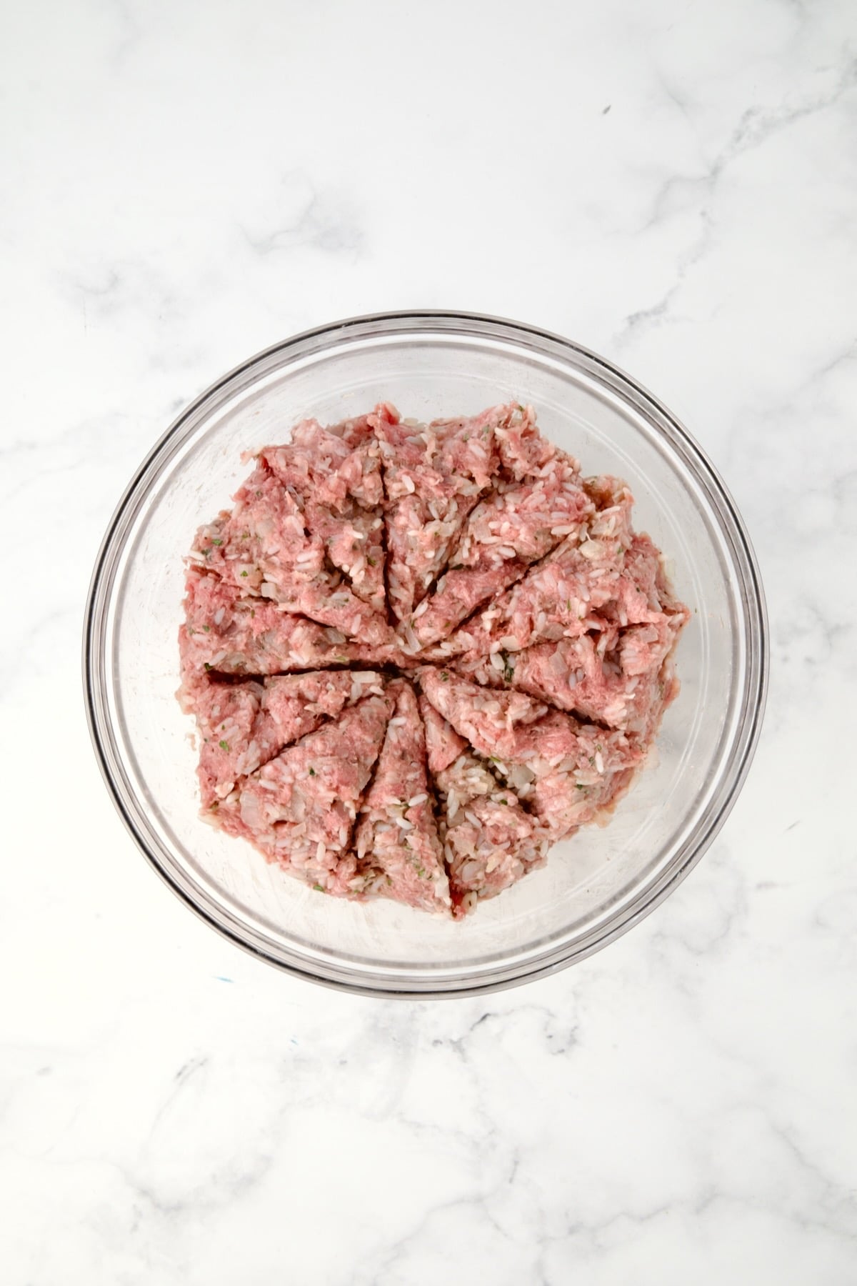 Filling for cabbage rolls in glass bowl divided into 12 sections.