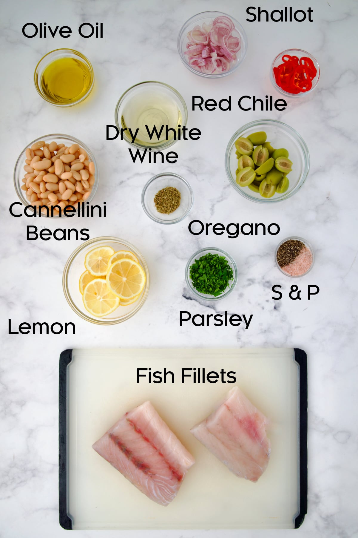 Ingredients for Mediterranean Fish and White Bean Skillet on marble countertop.