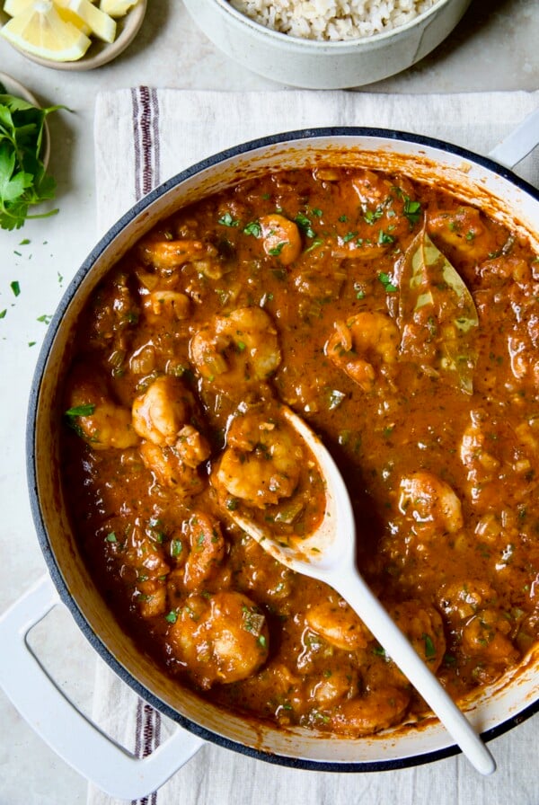 Finished Best Shrimp Creole in white enamel cast iron skillet with serving spoon.