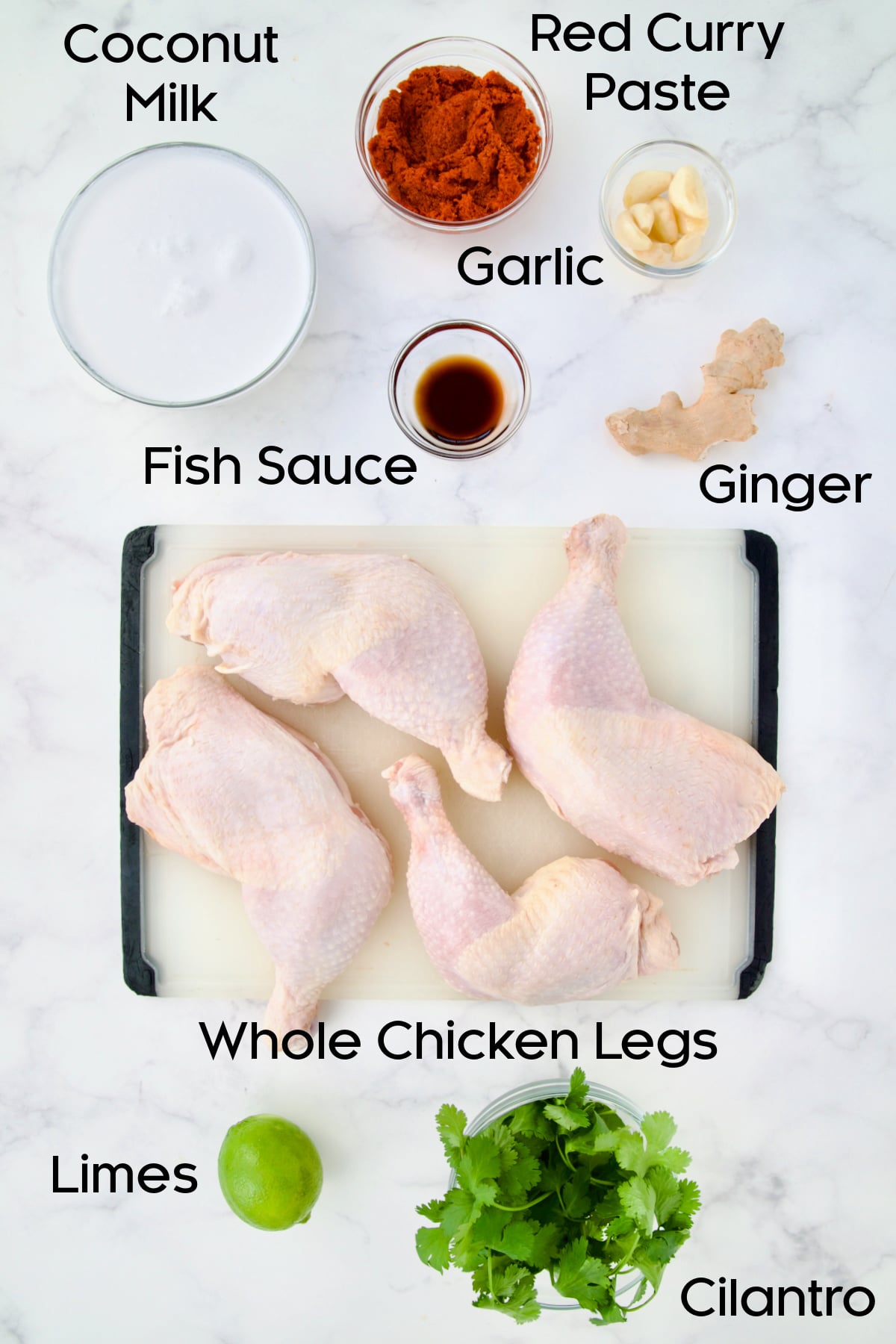 Ingredients for Thai Red Curry Braised Chicken Legs on marble countertop.