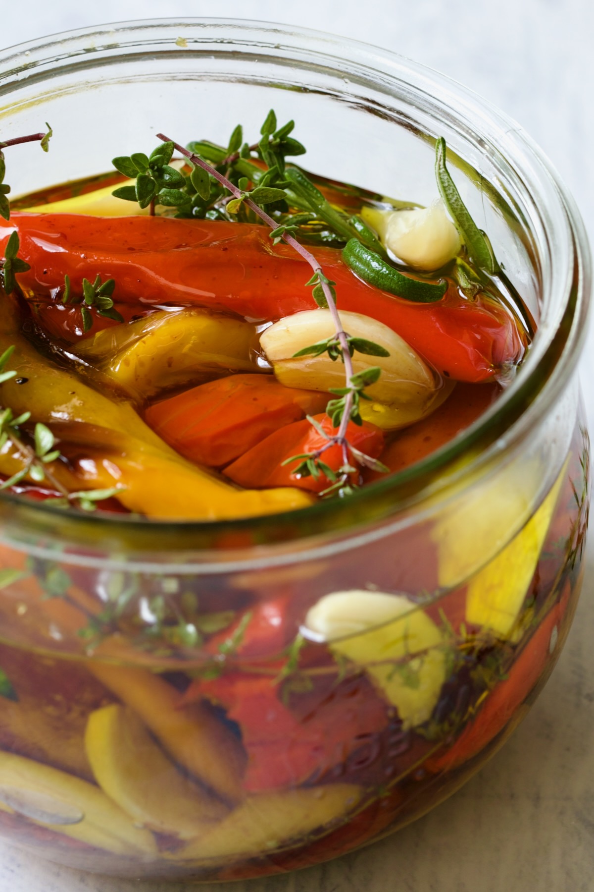 Roasted Mini Peppers with garlic and herbs in glass jar.