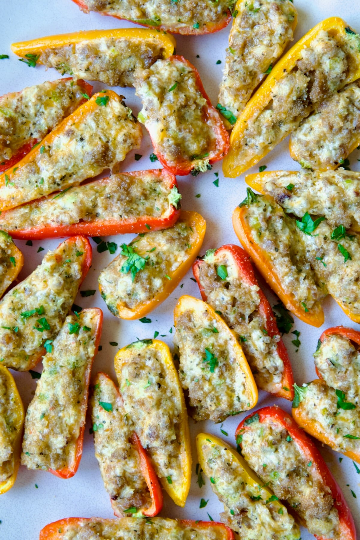 Stuffed Mini Peppers on white oval platter garnished with chopped fresh parsley.