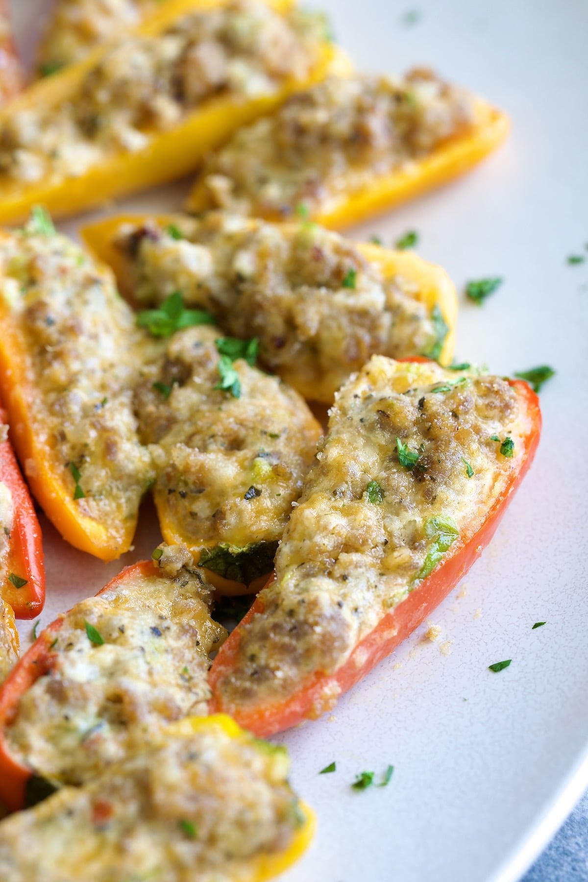Stuffed Mini Peppers on white oval platter garnished with chopped fresh parsley.