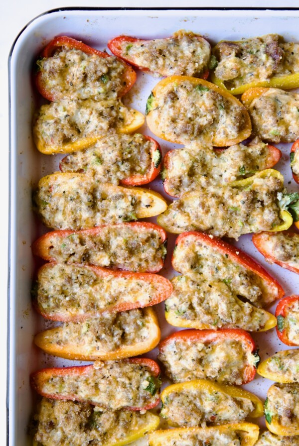 Baked Stuffed Mini Peppers on white enamel rimmed baking sheet.