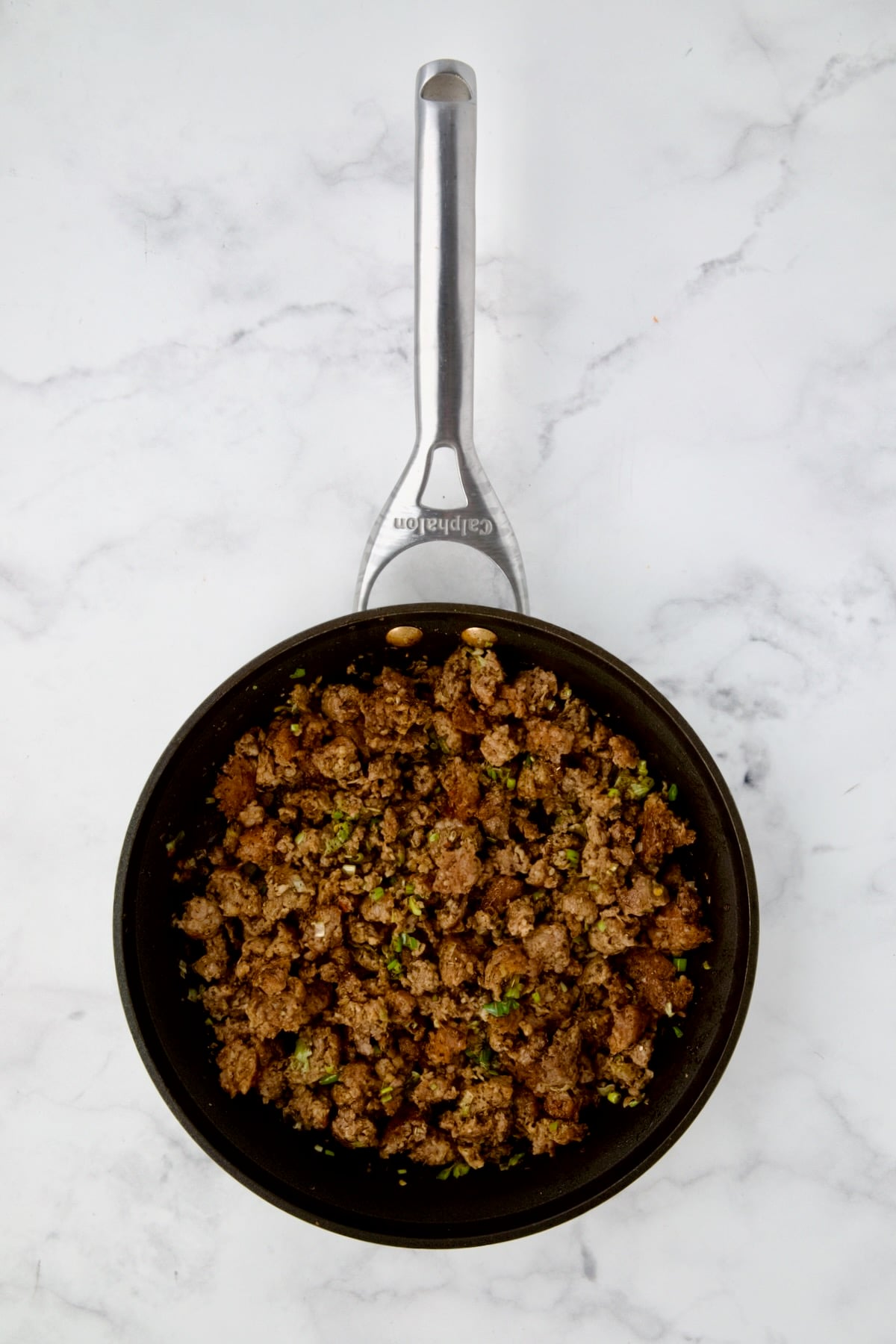 Cooked Italian sausage, scallions and Italian seasoning in nonstick skillet.