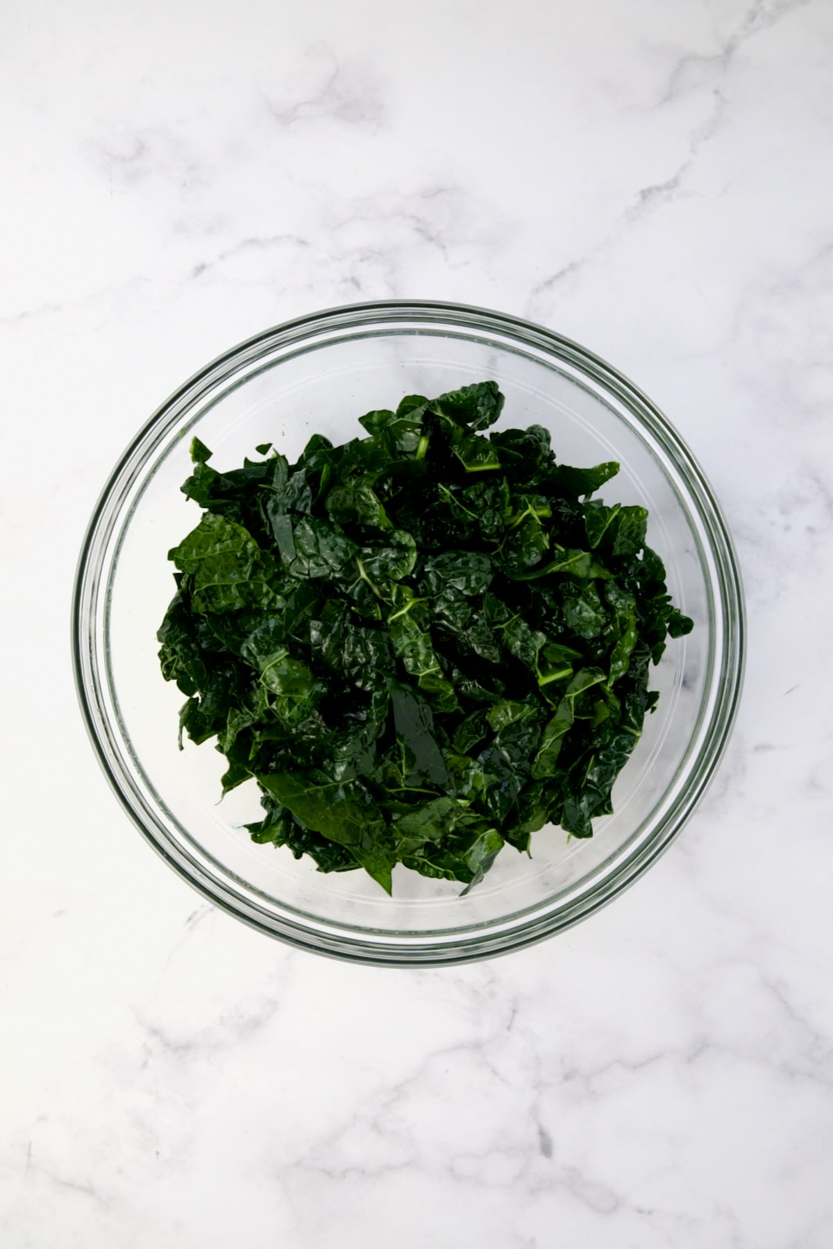 Tuscan kale in glass bowl after being massaged.