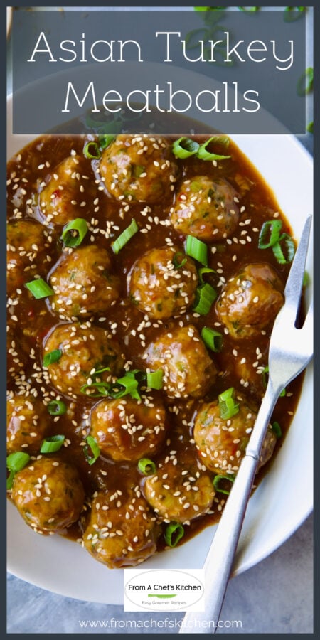 Asian Turkey Meatballs in oval white serving dish with serving fork.