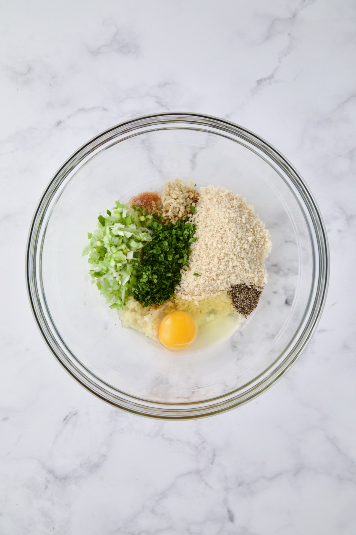 Ingredients except for ground turkey for meatballs in glass bowl before being combined.