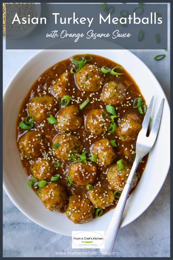 Asian Turkey Meatballs in oval white serving dish with serving fork.
