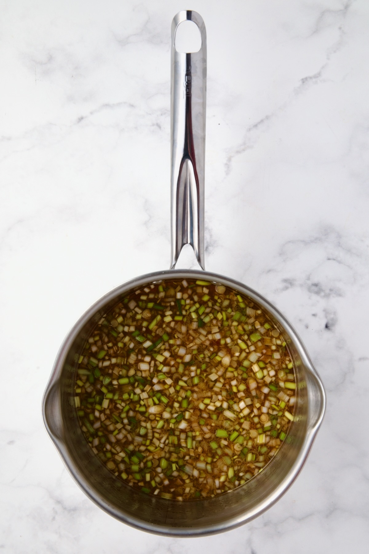 Ingredients for sauce for meatballs in stainless steel saucepan before being simmered.