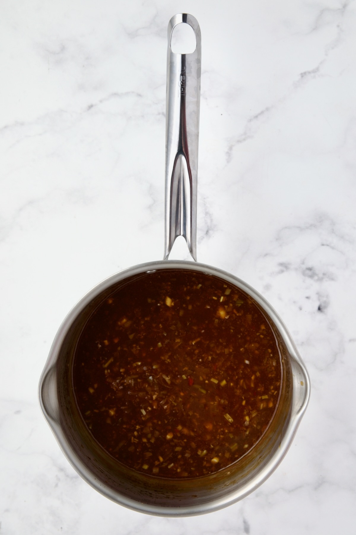 Ingredients for sauce for meatballs in stainless steel saucepan after being simmered and thickened.