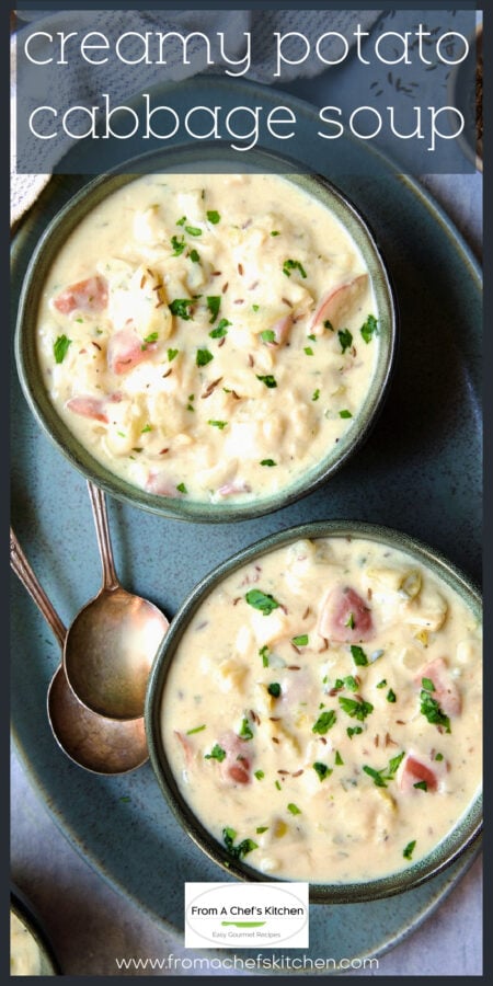 Two bowls of creamy potato soup on green platter.
