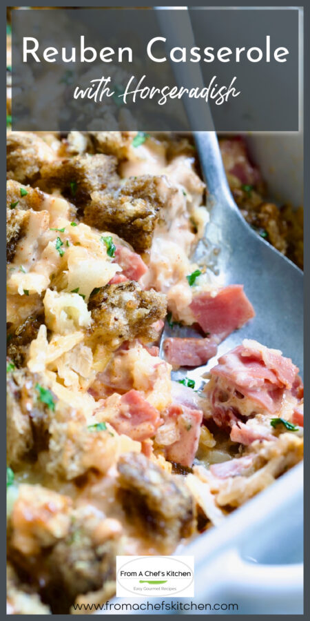 Reuben Casserole in white baking dish with serving spoon.