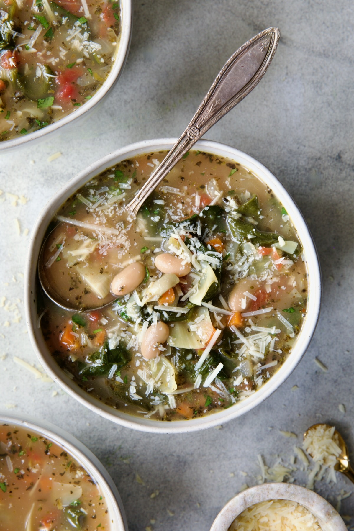 Vegetable Bean Soup in white bowl with spoon.