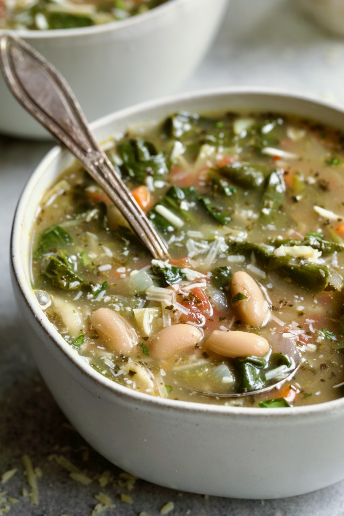 Vegetable Bean Soup in white bowl with spoon.