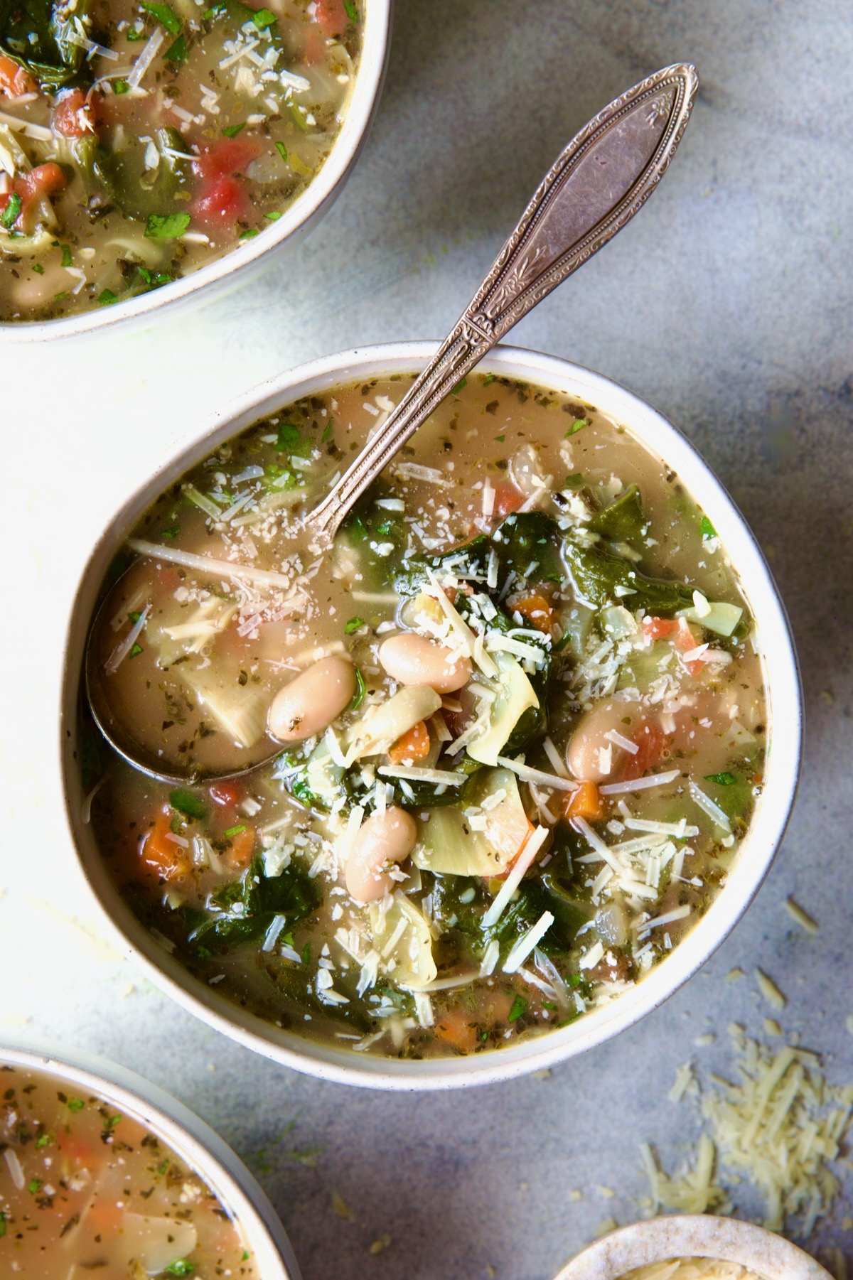 Vegetable Bean Soup in white bowl with spoon.