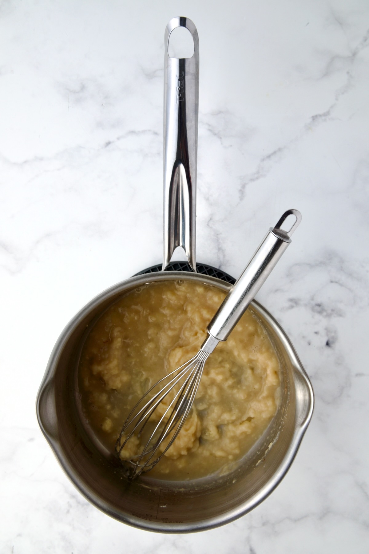 Butter, flour and sherry being whisked together in stainless steel saucepan.