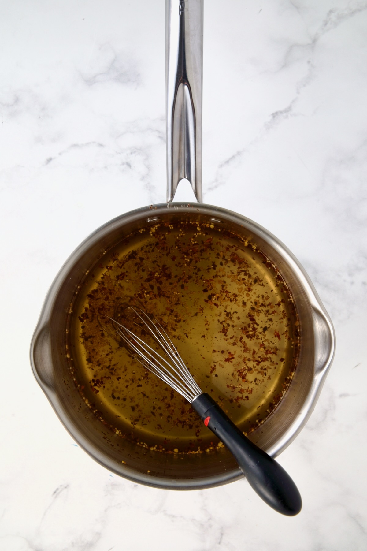 Brine in stainless steel saucepan with whisk.