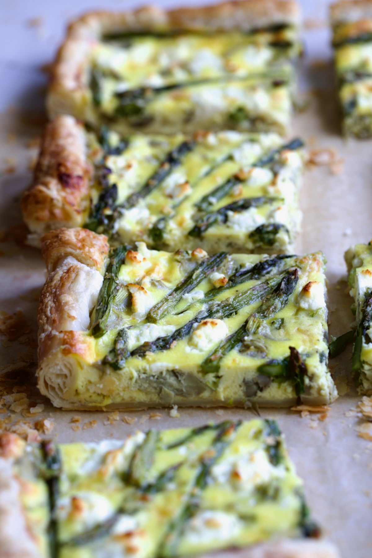Four pieces of Puff Pastry Vegetable Tart with focus on one to expose layers of puff pastry.