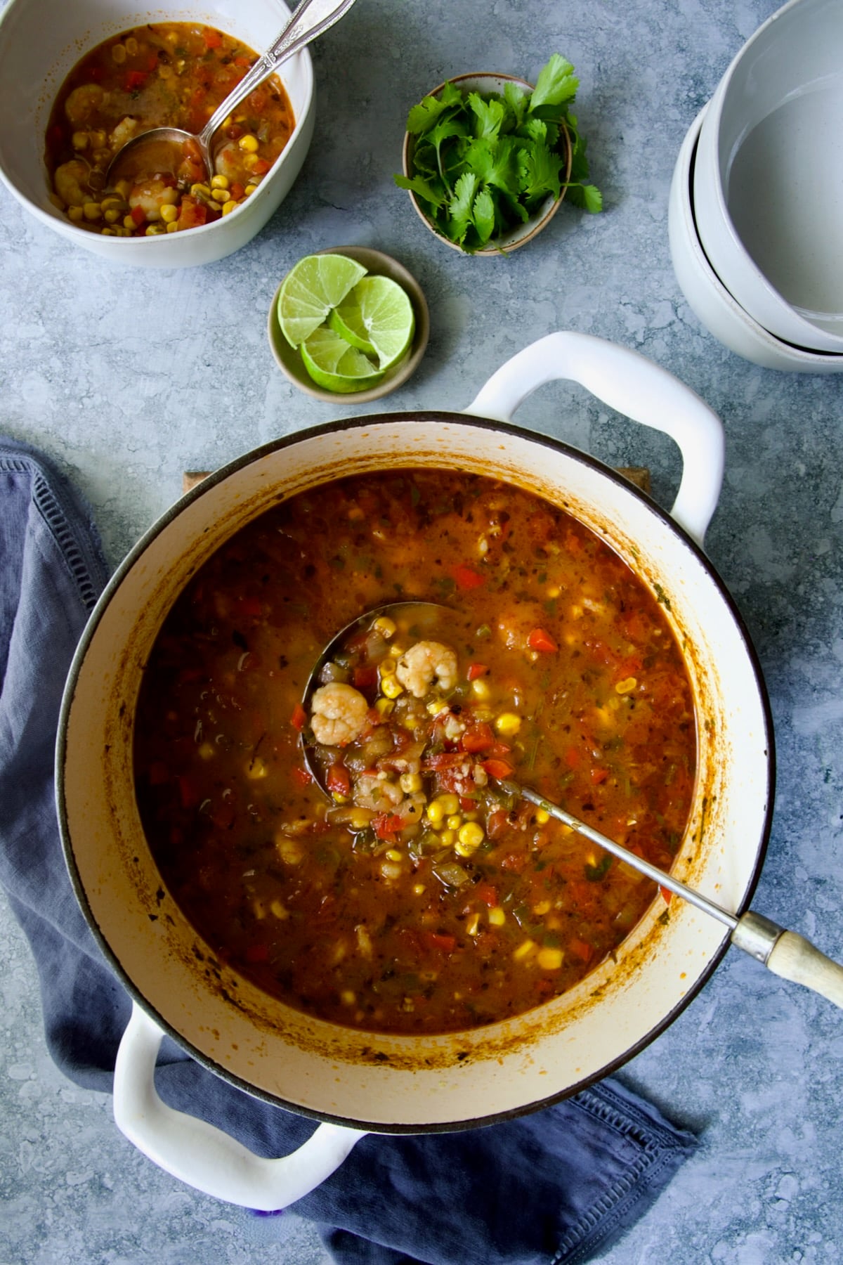 Shrimp and Corn Soup in Dutch oven with soup ladle taking some out.