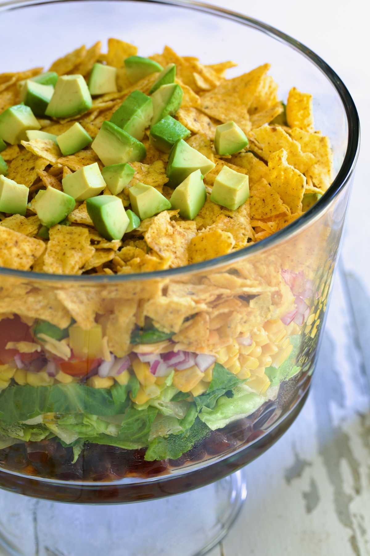 Southwestern Layered Salad in glass footed bowl.