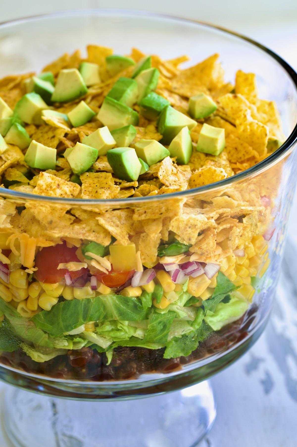 Southwestern Layered Salad in glass footed bowl.