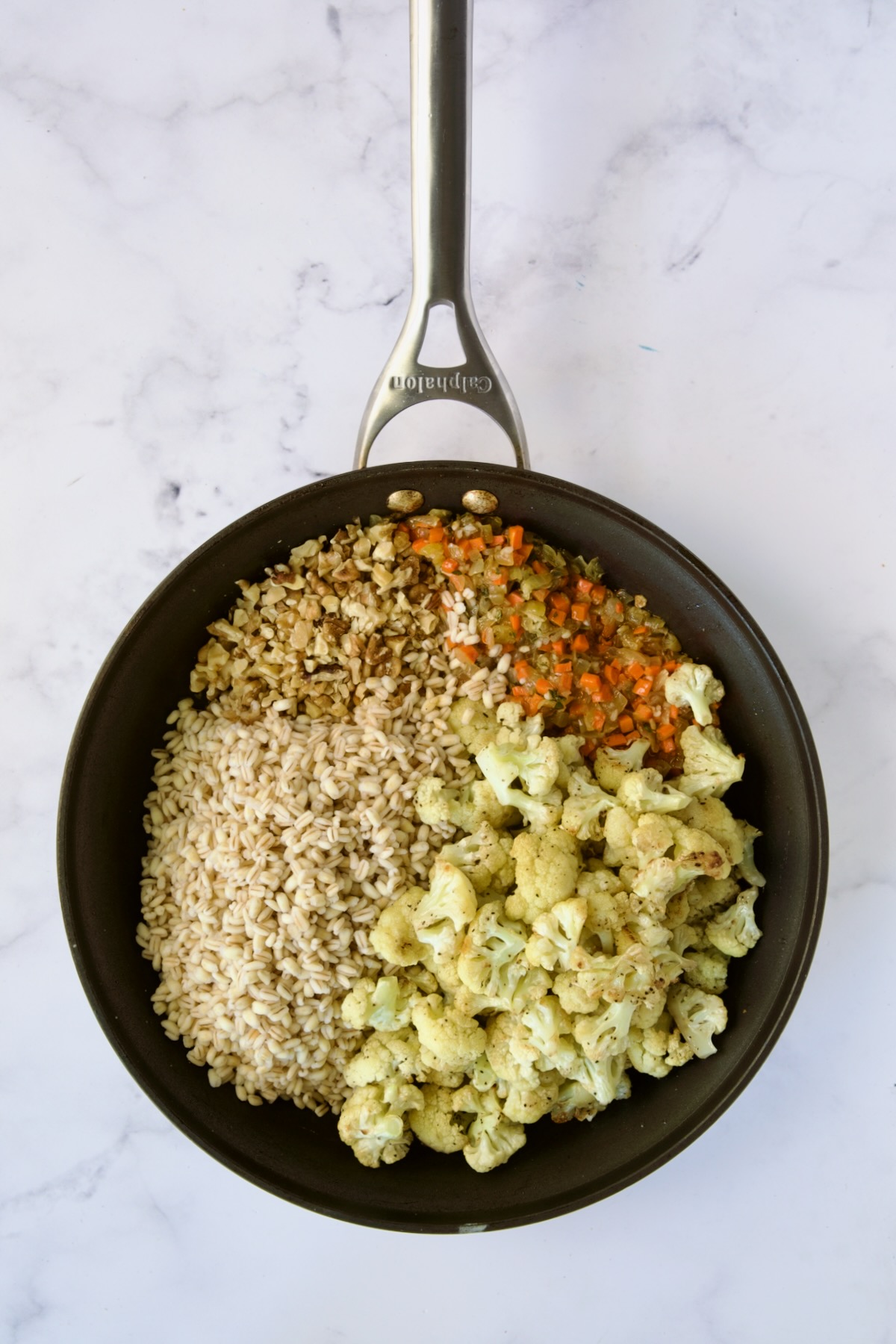 Cauliflower and barley added to nonstick skillet before being stirred together.