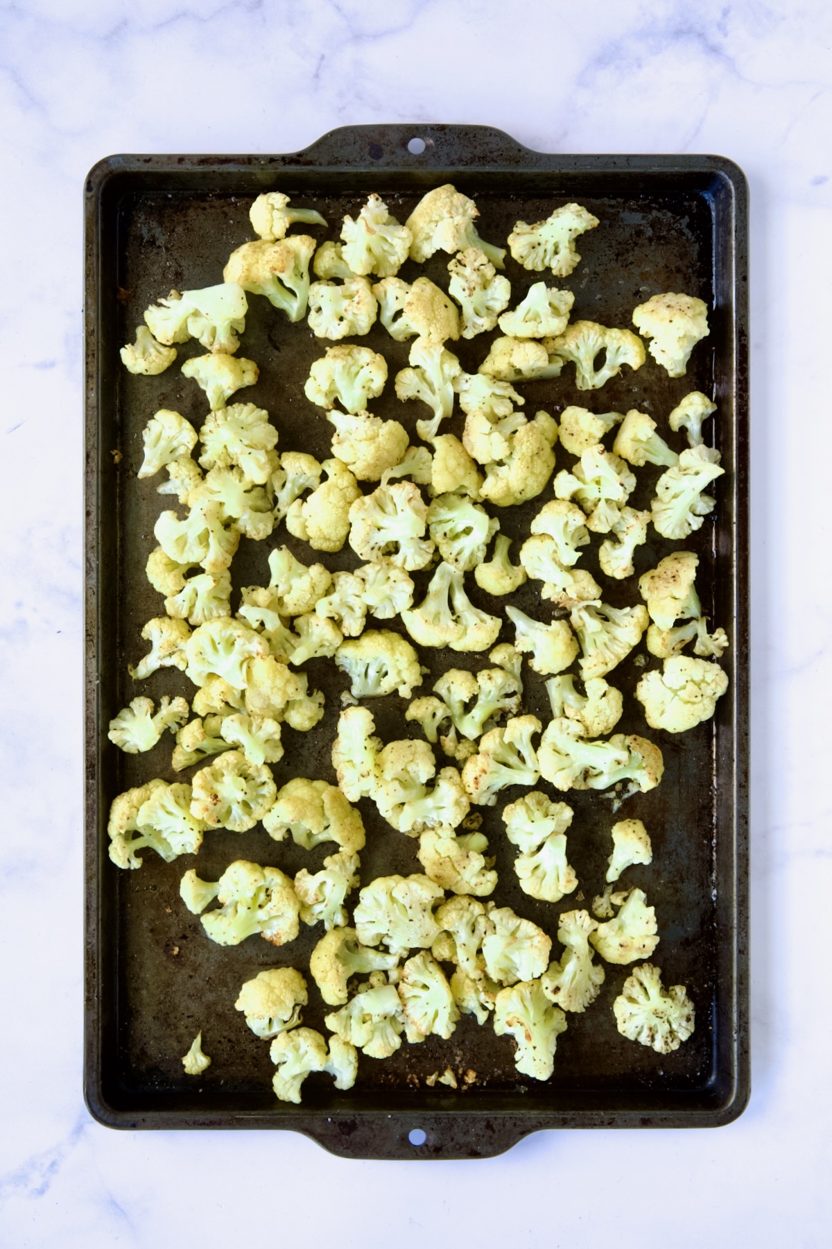 Roasted cauliflower on rimmed sheet pan.