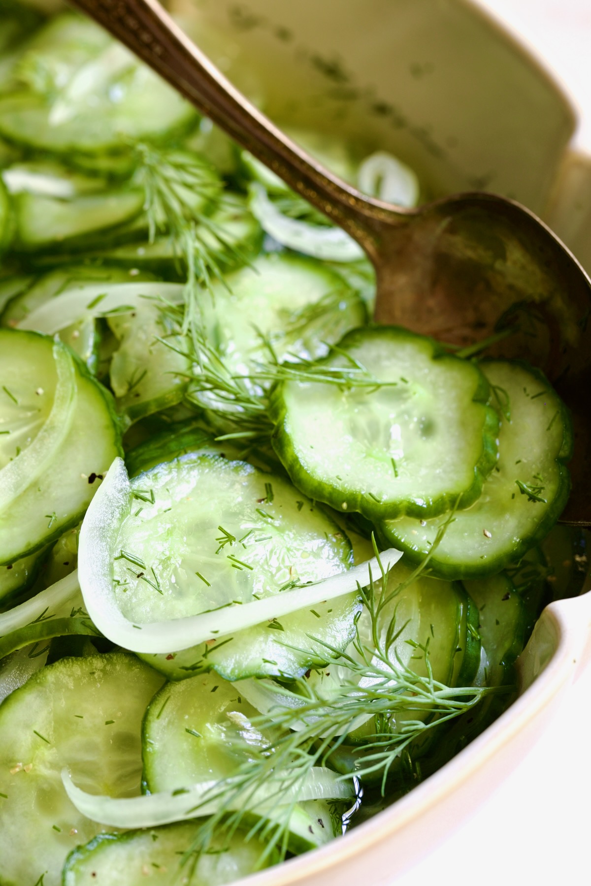 Cucumber Onion Salad in serving bowl with serving spoon.