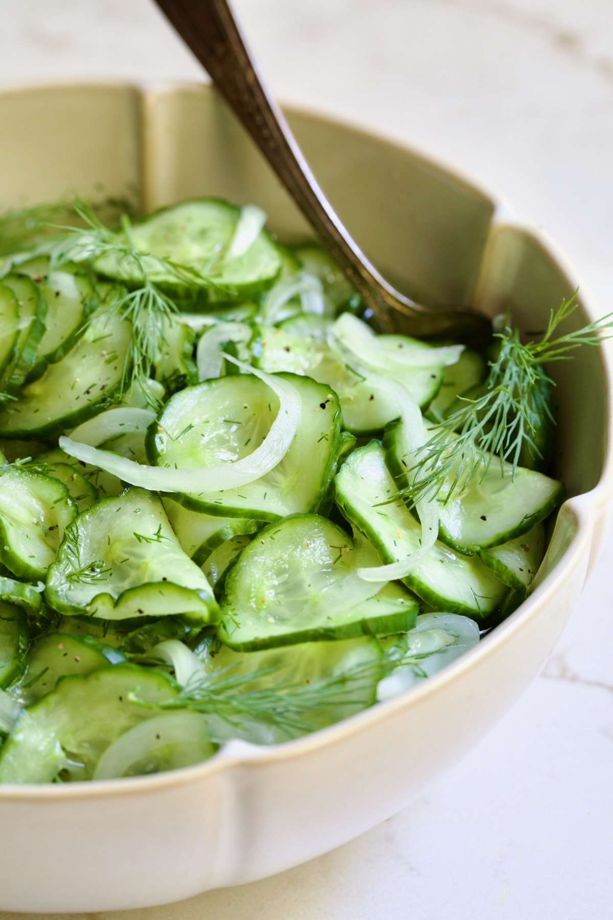 Cucumber Onion Salad in serving bowl with serving spoon.