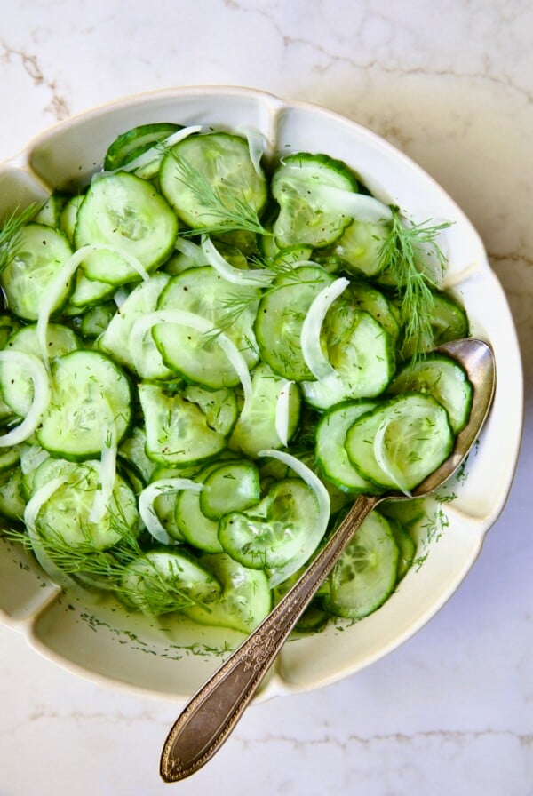 Cucumber Onion Salad in serving bowl with serving spoon.