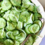 Cucumber Onion Salad in serving bowl with serving spoon.