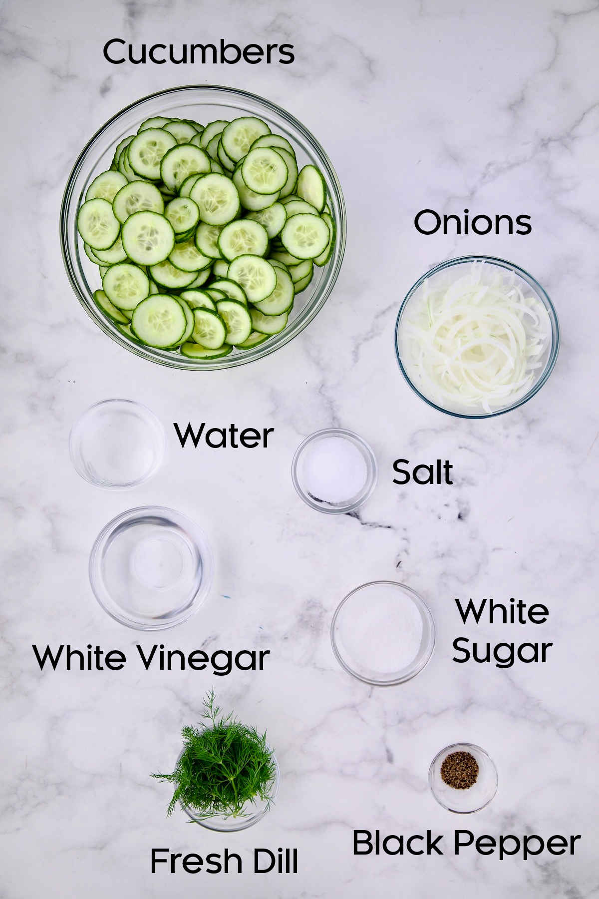 Ingredients for Cucumber Onion Salad in glass bowls.