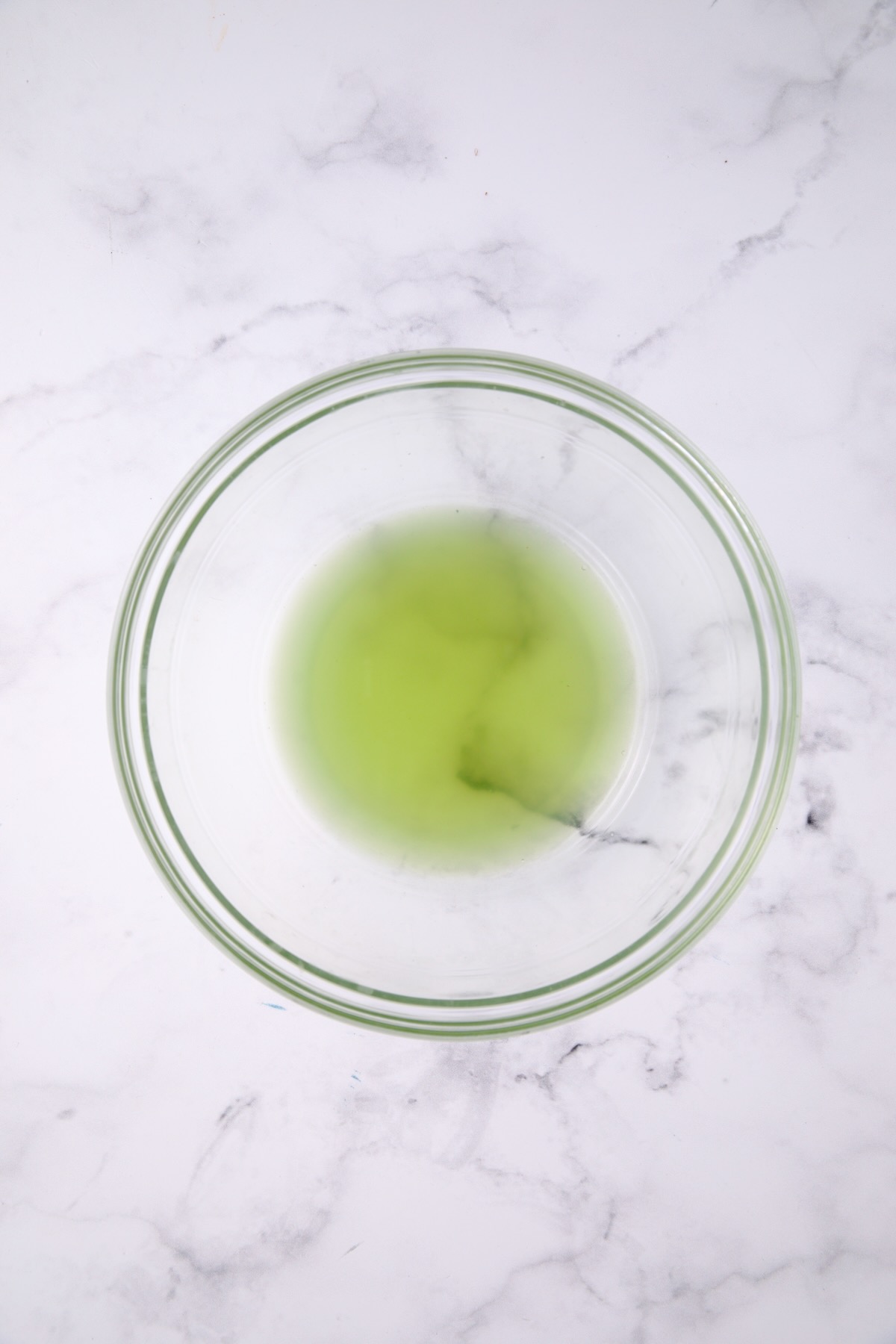 Liquid from cucumbers in glass bowl.