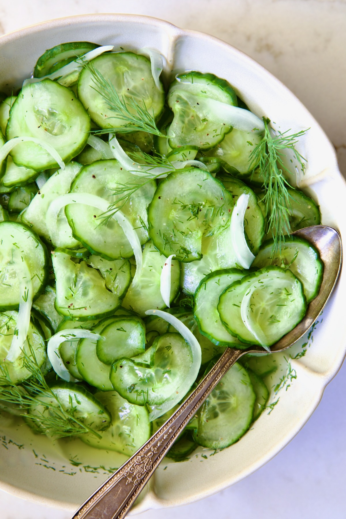 Cucumber Onion Salad in serving bowl with serving spoon.
