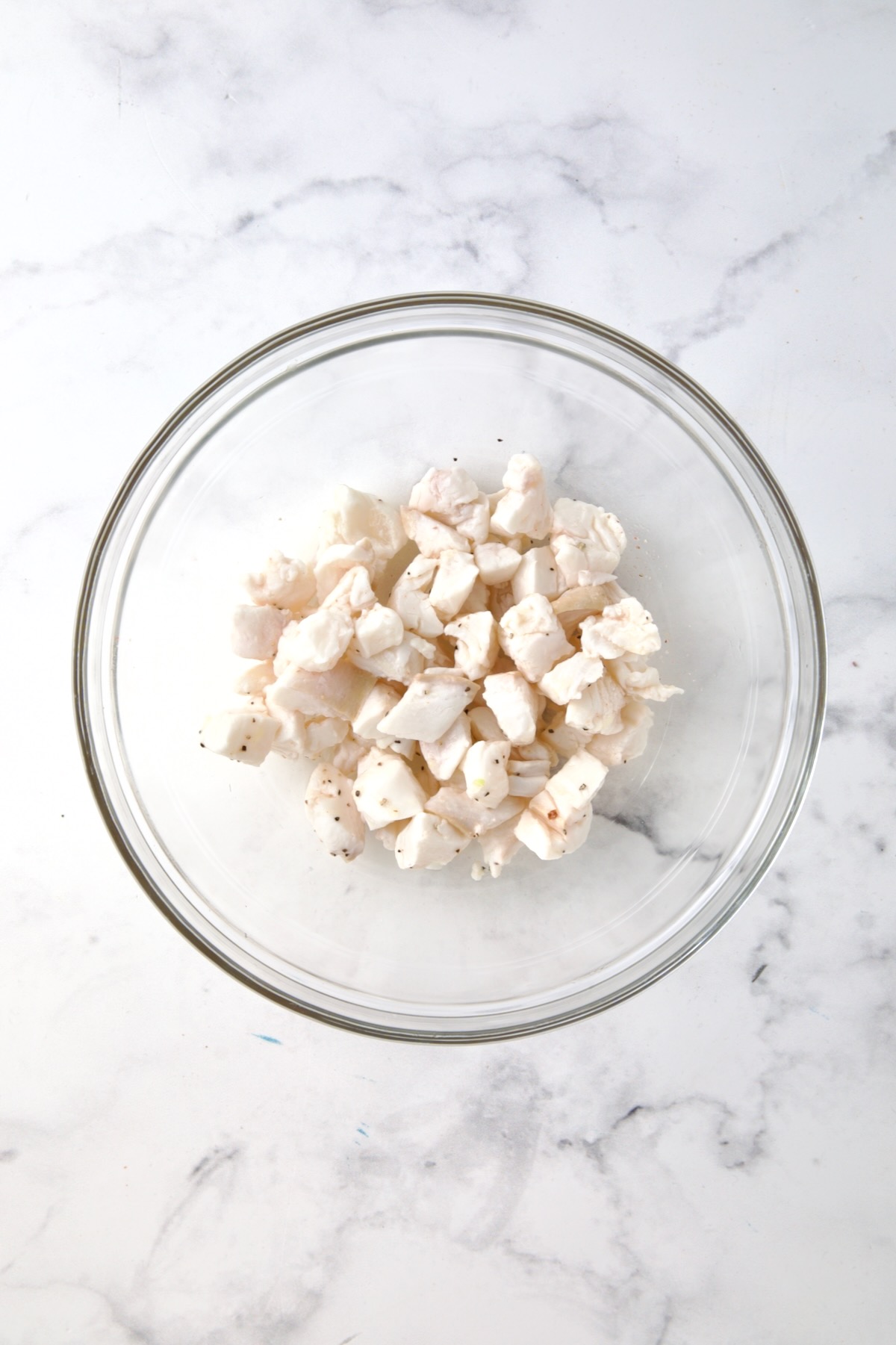 Cubed cured halibut in glass bowl.
